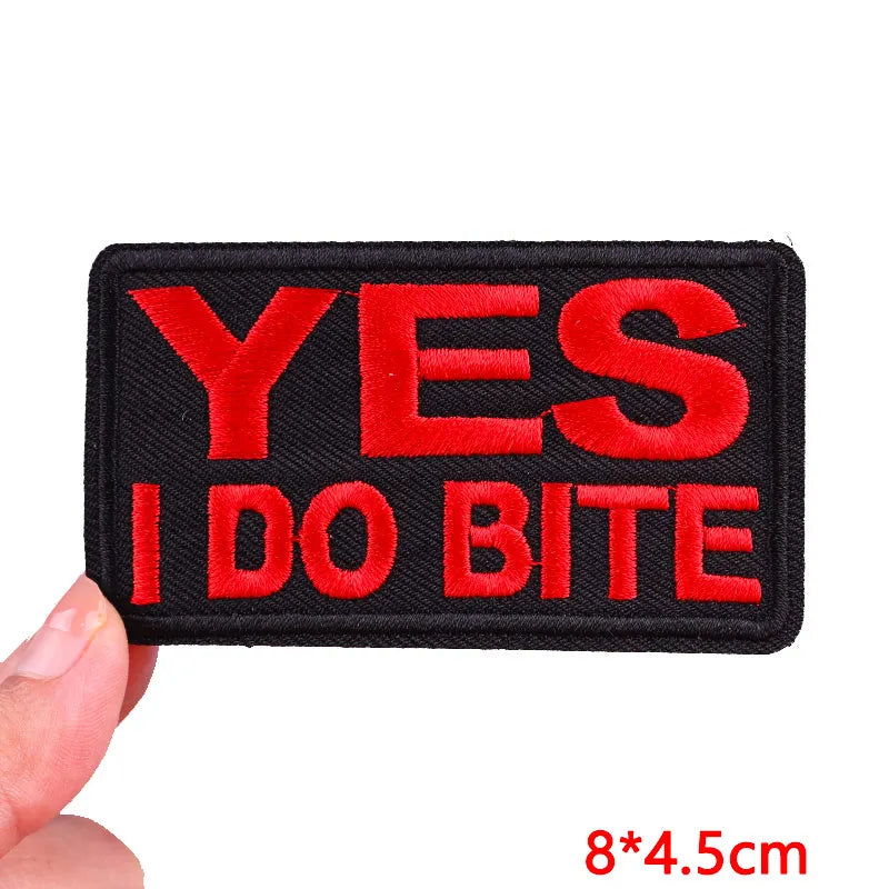 Black embroidered iron-on letter patch with red text saying YES I DO BITE