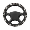 Black steering wheel cover with a skull design and anti-slip grip.