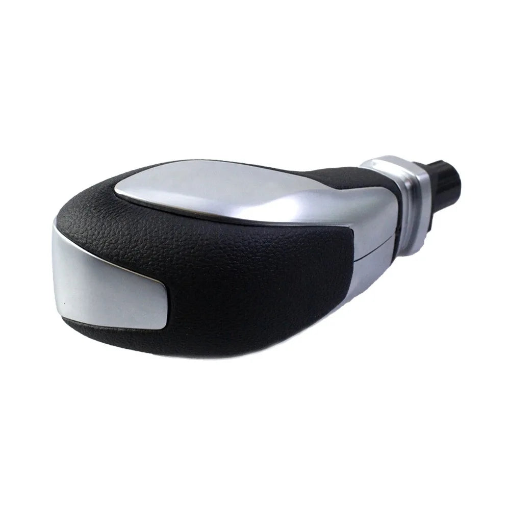 A leather-wrapped gear shift knob with a silver accent cap.