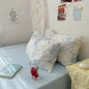 A light blue floral duvet cover set with two matching pillowcases resting on a light blue surface.