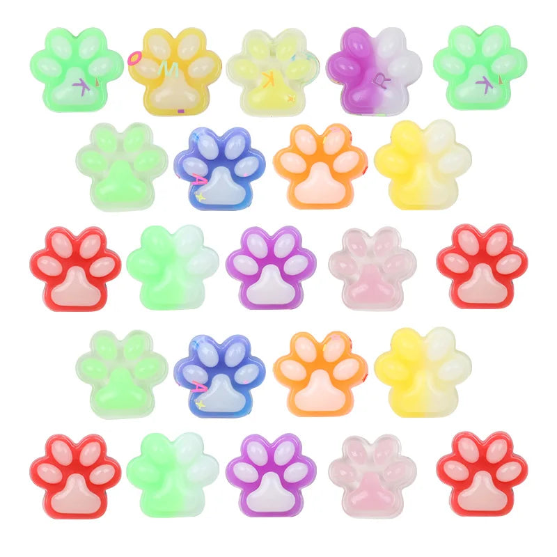 A collection of colorful squishy cat paw fidget toys in various shades including green, yellow, purple, and pink.