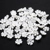 A pile of 100 white acrylic pearl spacer beads shaped like small flowers for jewelry making