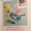 A set of baby bottle accessories including a yellow baby doll, a pink bottle, and various silicone parts.
