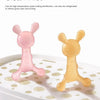A pink silicone cartoon rabbit teether is shown floating on a white plate.
