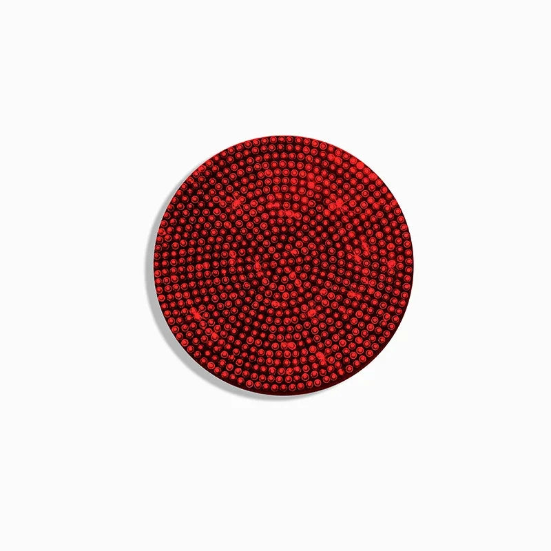 A close-up view of a red, textured non-slip diamond pattern coaster.