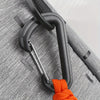 A close-up of a black bungee tether with a carabiner hook attached to a gray fabric strap.