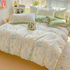A floral duvet cover set featuring light green and white patterns with matching pillows on a bed.
