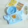 Light blue fleece hoodie with a tan bear patch and drawstring, displayed on a white surface.