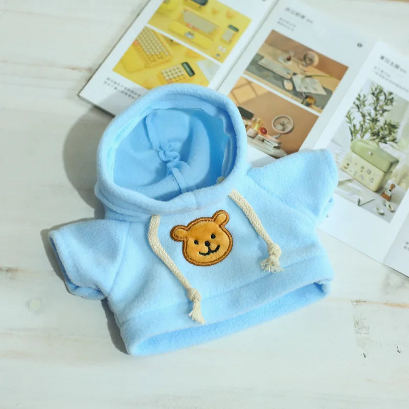 Light blue fleece hoodie with a tan bear patch and drawstring, displayed on a white surface.