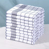 A stack of six white and gray absorbent lint-free dish cloths or kitchen towels are neatly folded on a white surface.