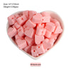 A bowl filled with pink silicone heart and star shaped beads for DIY jewelry making