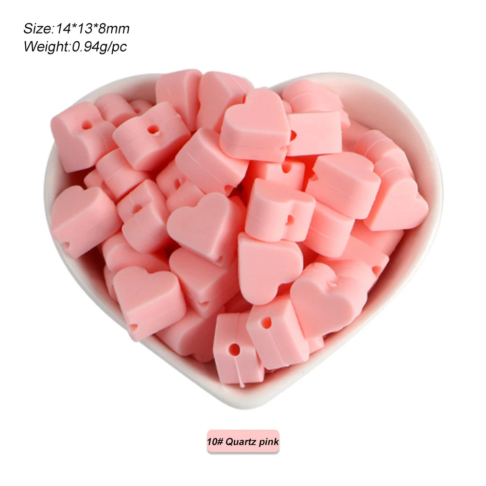 A bowl filled with pink silicone heart and star shaped beads for DIY jewelry making