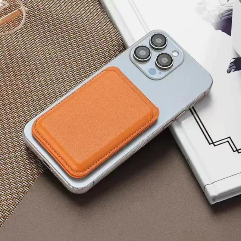 An orange magnetic leather wallet case with a kickstand is shown resting on a beige surface next to an iPhone.