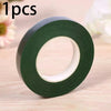 A roll of dark green chenille craft stems for DIY projects shown on a wooden surface.