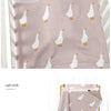 A light pink soft cotton baby swaddle blanket featuring a repeating cartoon print of white birds.