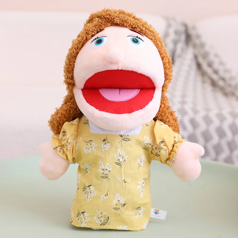 A soft plush hand puppet with brown hair and red lips wearing a yellow floral shirt.