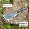 A forged steel axe with a round style blade and handle, shown resting on a rock.
