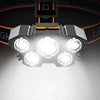 A close-up view of a black 5-LED waterproof headlamp with multiple bright lights illuminating a white surface.