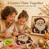 A woman and a girl are painting a Christmas Santa figure using pearl beads on a canvas in a cozy setting.