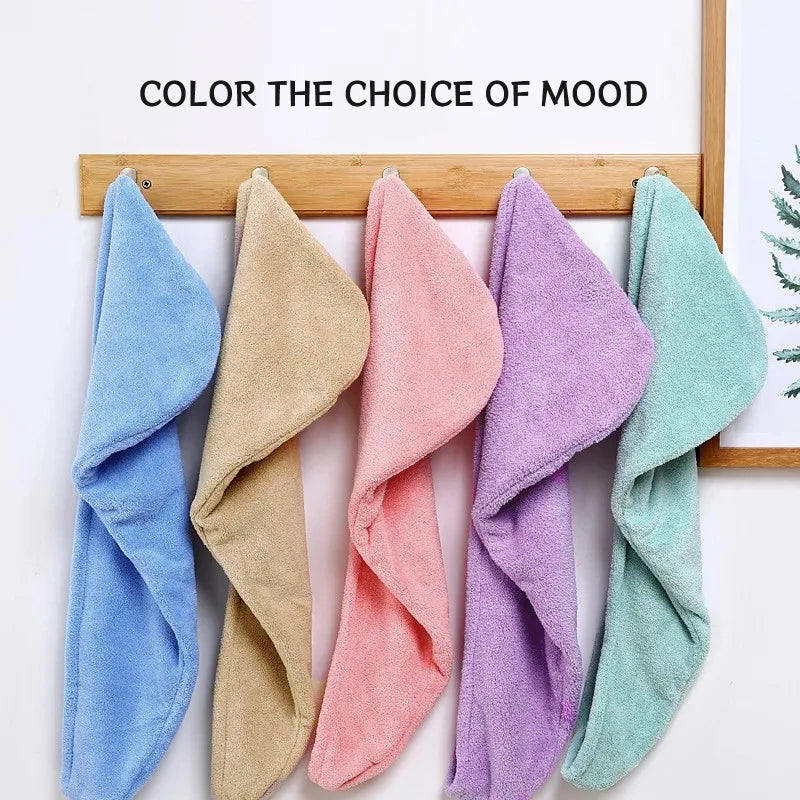 A collection of colorful microfiber hair towel wraps hanging on a wooden rack.