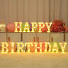 LED letter night lights spelling HAPPY BIRTHDAY arranged on a table with colorful balloons and glitter