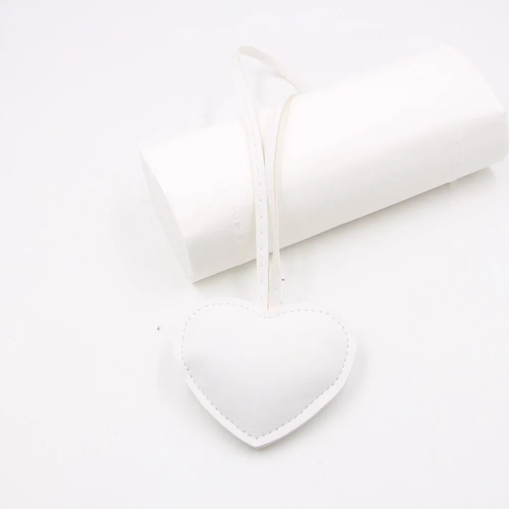 White heart-shaped PU leather keychain with a cotton peach charm