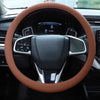 A close-up view of a brown silicone steering wheel cover on a car's steering wheel.