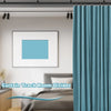 A teal curtain track room divider with fabric panels hanging from a ceiling mount in a bright room.