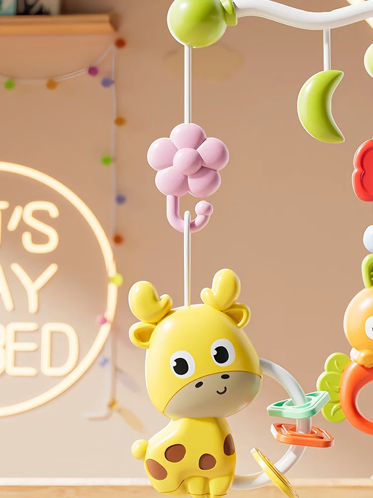 A yellow giraffe toy is hanging from a musical crib mobile with various colorful shapes.
