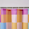 A shower curtain featuring a retro plaid design with bright rainbow colors including purple, orange, pink, and blue.