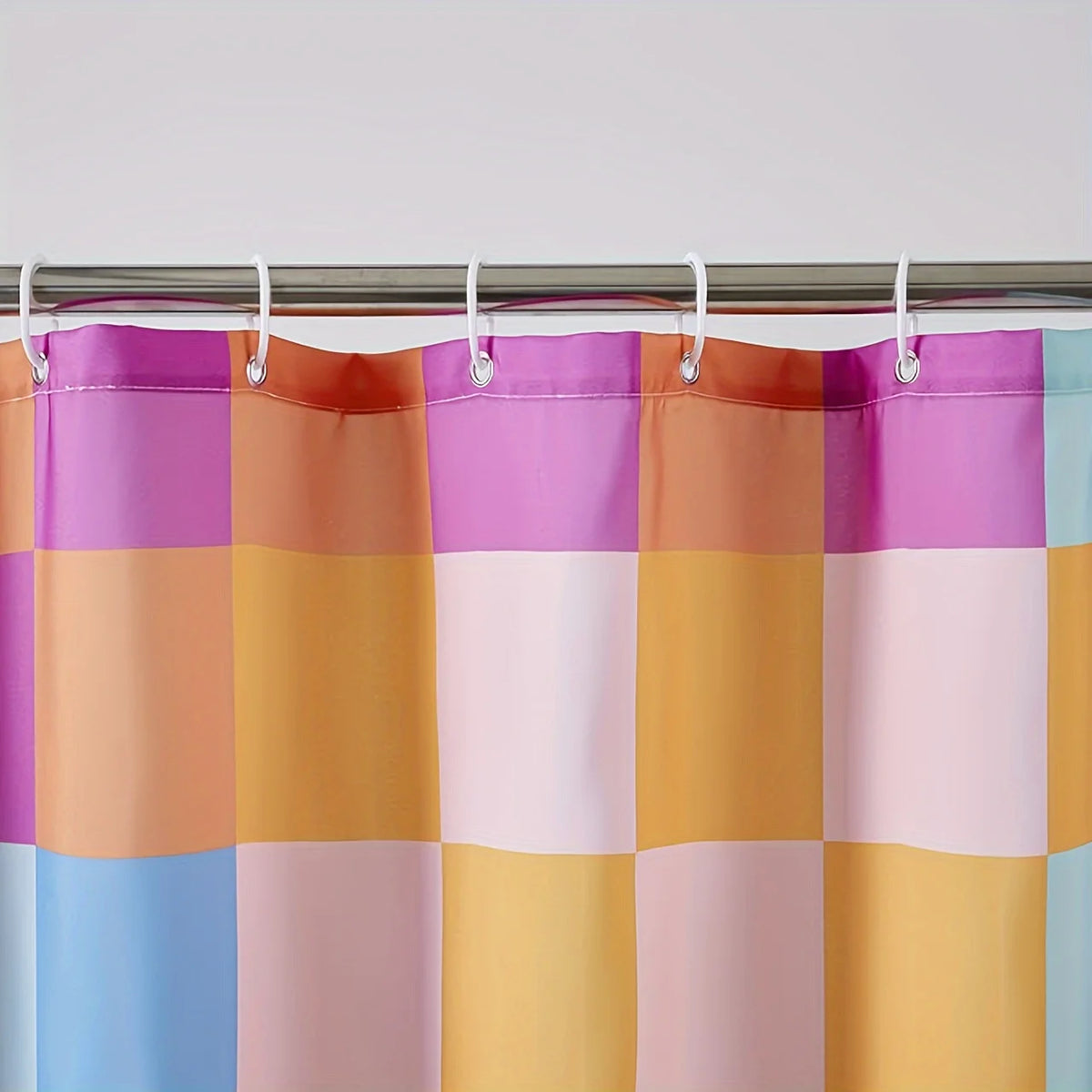A shower curtain featuring a retro plaid design with bright rainbow colors including purple, orange, pink, and blue.