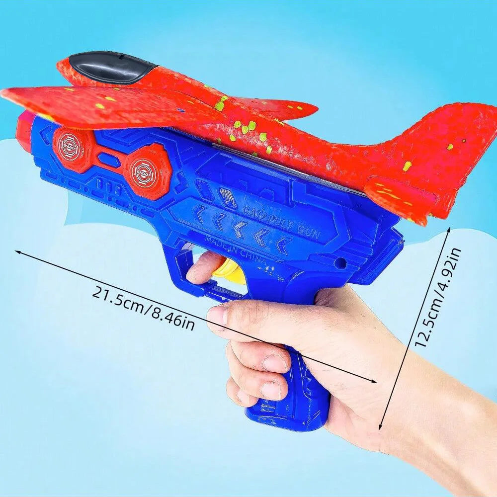 A hand holds a red and blue foam catapult glider plane toy set against a light blue background.