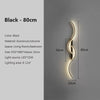 A black aluminum and silicone modern minimalist LED wall lamp illuminating a vertical curved light design.