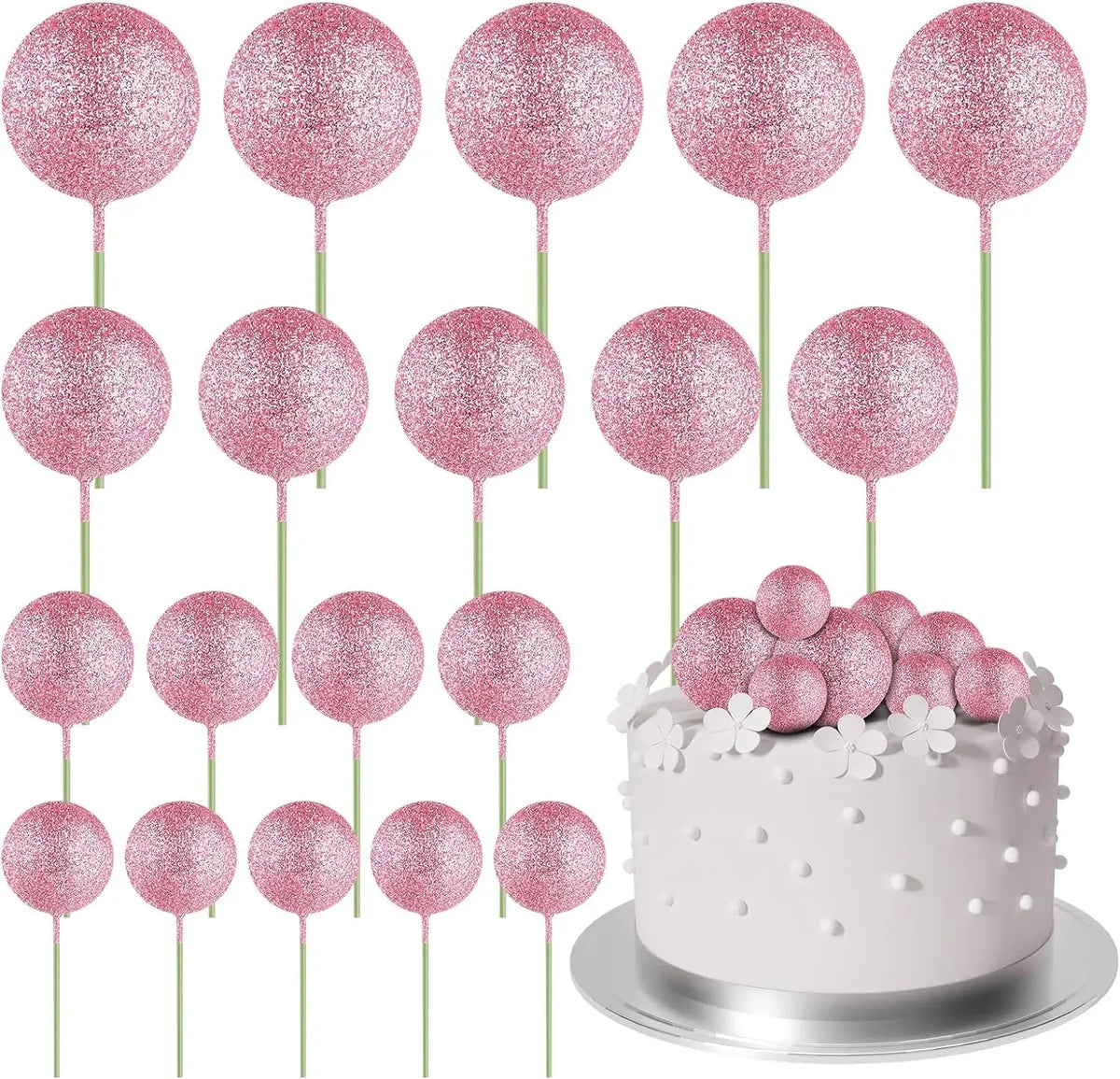 Eine Sammlung von 20 rosa Glitzer-Ball-Kekstoppern auf grünen Stäbchen um einen weißen Kuchen arrangiert.