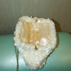 A white sequin beaded chain shoulder clutch bag with a light pink lining and gold chain detail.