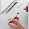 A hand holds a white retractable gel pen with black ink and a coiled spring, surrounded by other pens.