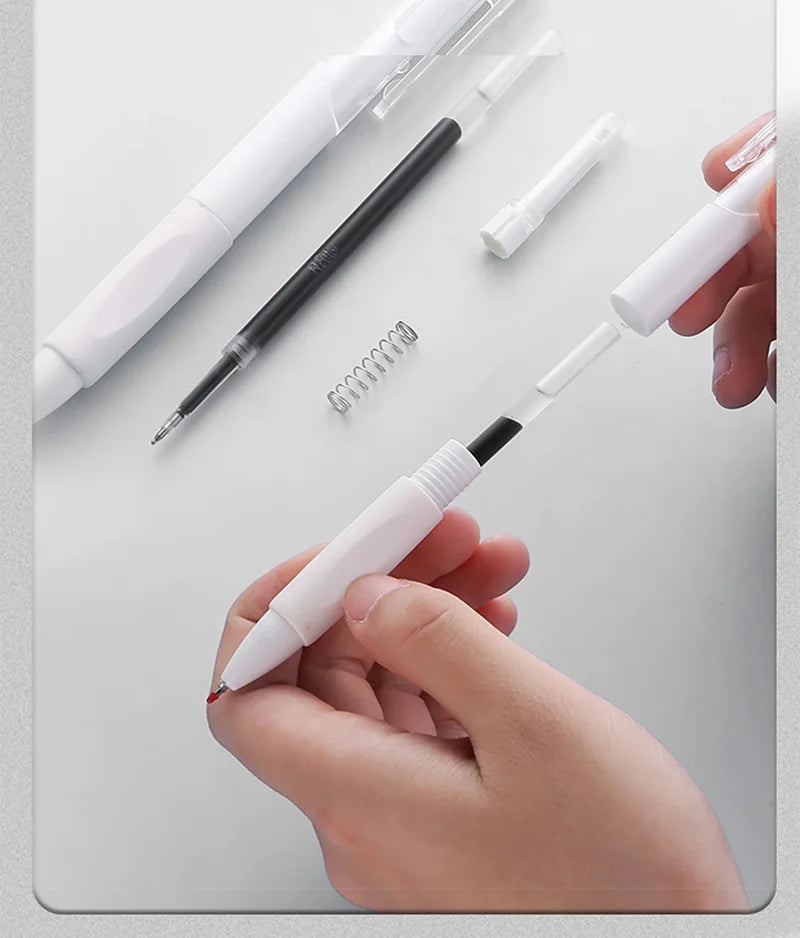 A hand holds a white retractable gel pen with black ink and a coiled spring, surrounded by other pens.