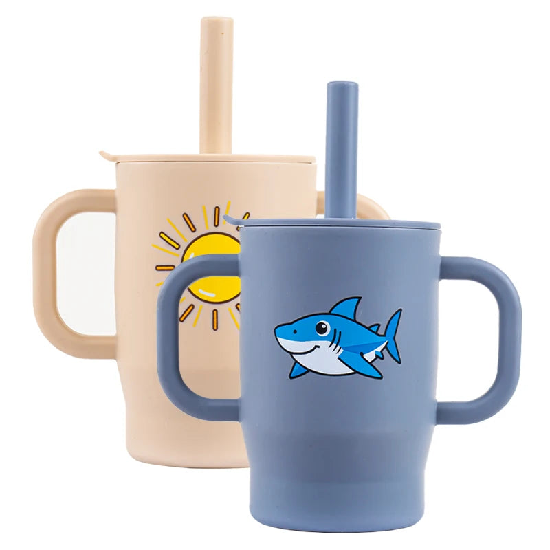 A light blue silicone training cup with a straw and handles, featuring a fish design.