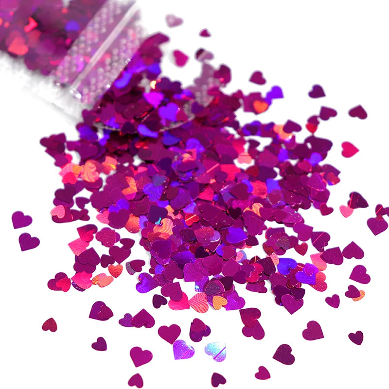 A pile of shiny holographic pink and purple star sequins for resin crafts.