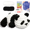 A finished white and black panda crochet toy alongside yarn, tools, and a DIY guide.