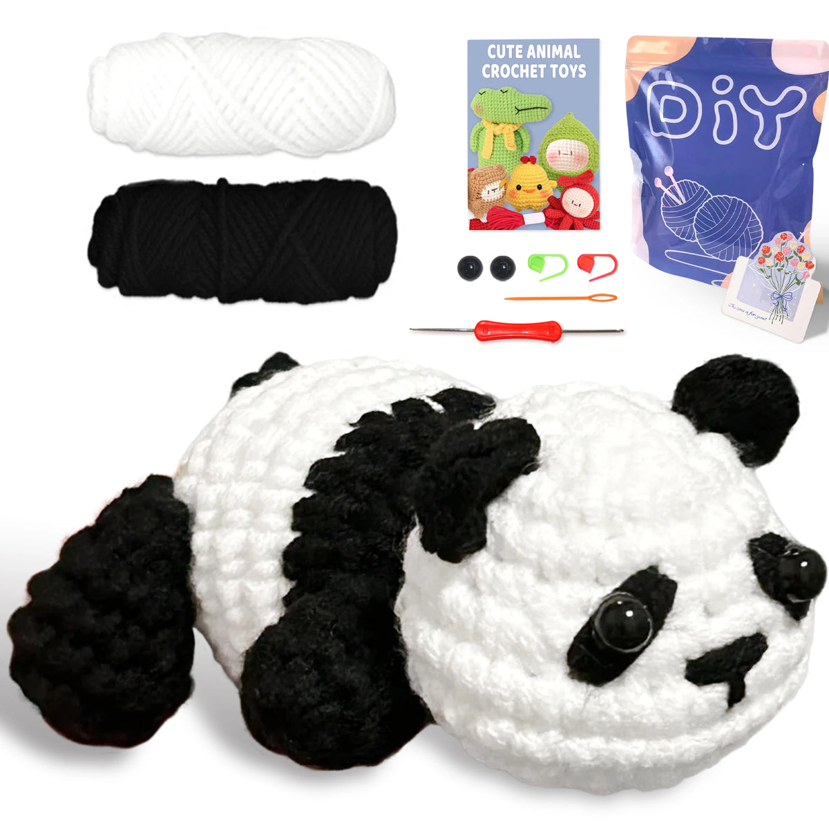 A finished white and black panda crochet toy alongside yarn, tools, and a DIY guide.