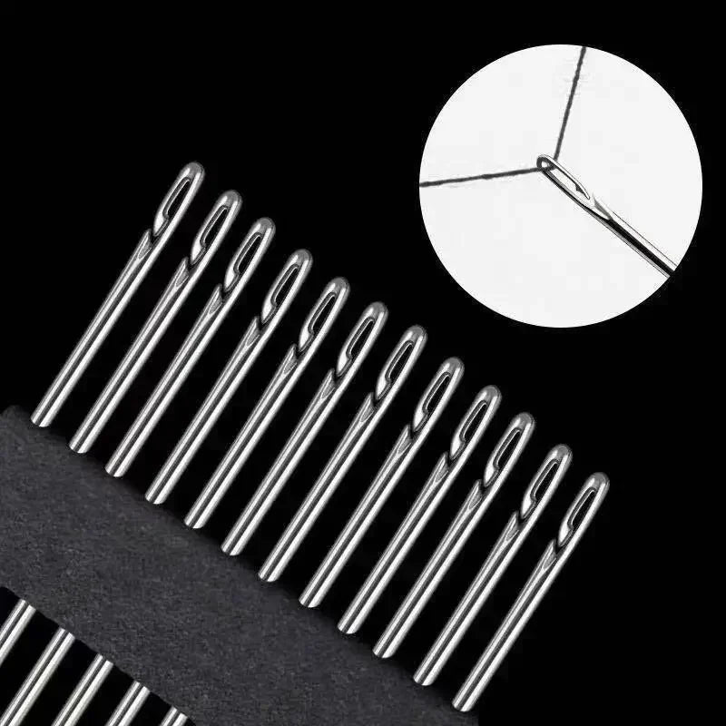 A close-up view of stainless steel self-threading sewing needles against a black background.