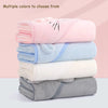 A stack of multiple colored, fuzzy hooded baby bathrobe towels with cartoon designs.