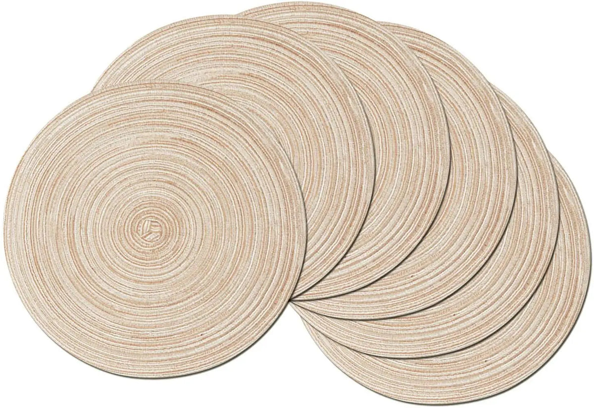 A set of six round, beige braided placemats stacked and arranged on a surface.