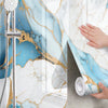 Marble peel-and-stick wallpaper featuring blue and gold marble patterns on a shower wall.