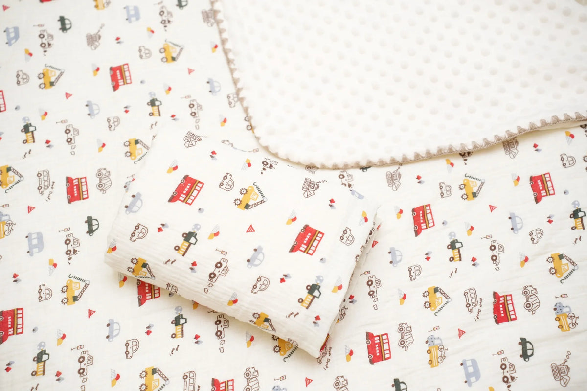 A white cotton gauze baby swaddle blanket with an adorable bear print pattern.