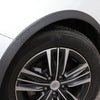 Close-up view of a black aftermarket wheel with a polished silver multi-spoke rim and textured carbon fiber-look fender trim.