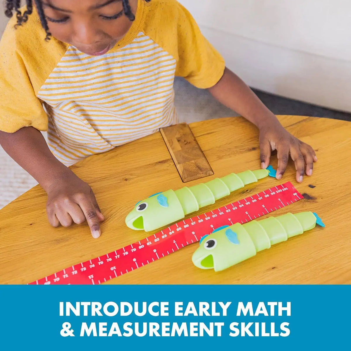 A child is using a yellow and striped shirt to interact with a set of colorful, telescoping measuring tools.