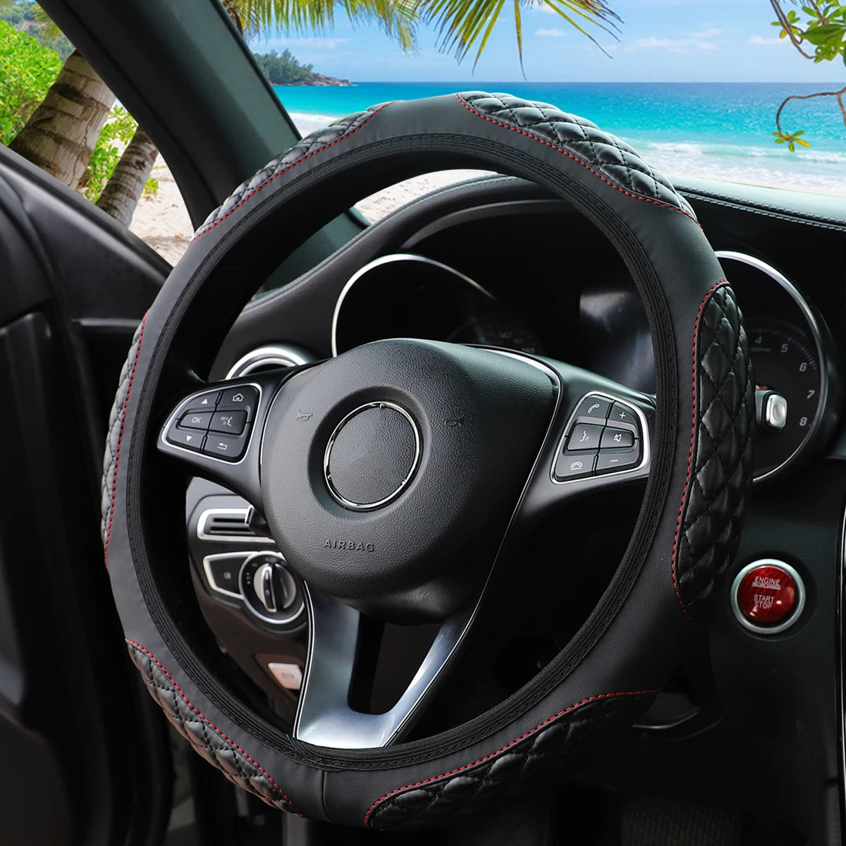 A black steering wheel with a red stitched leather cover is shown inside a car, viewed from the driver's perspective.