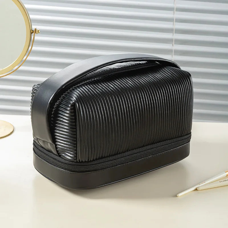 A black PU leather makeup bag set is shown on a light surface next to a circular mirror.
